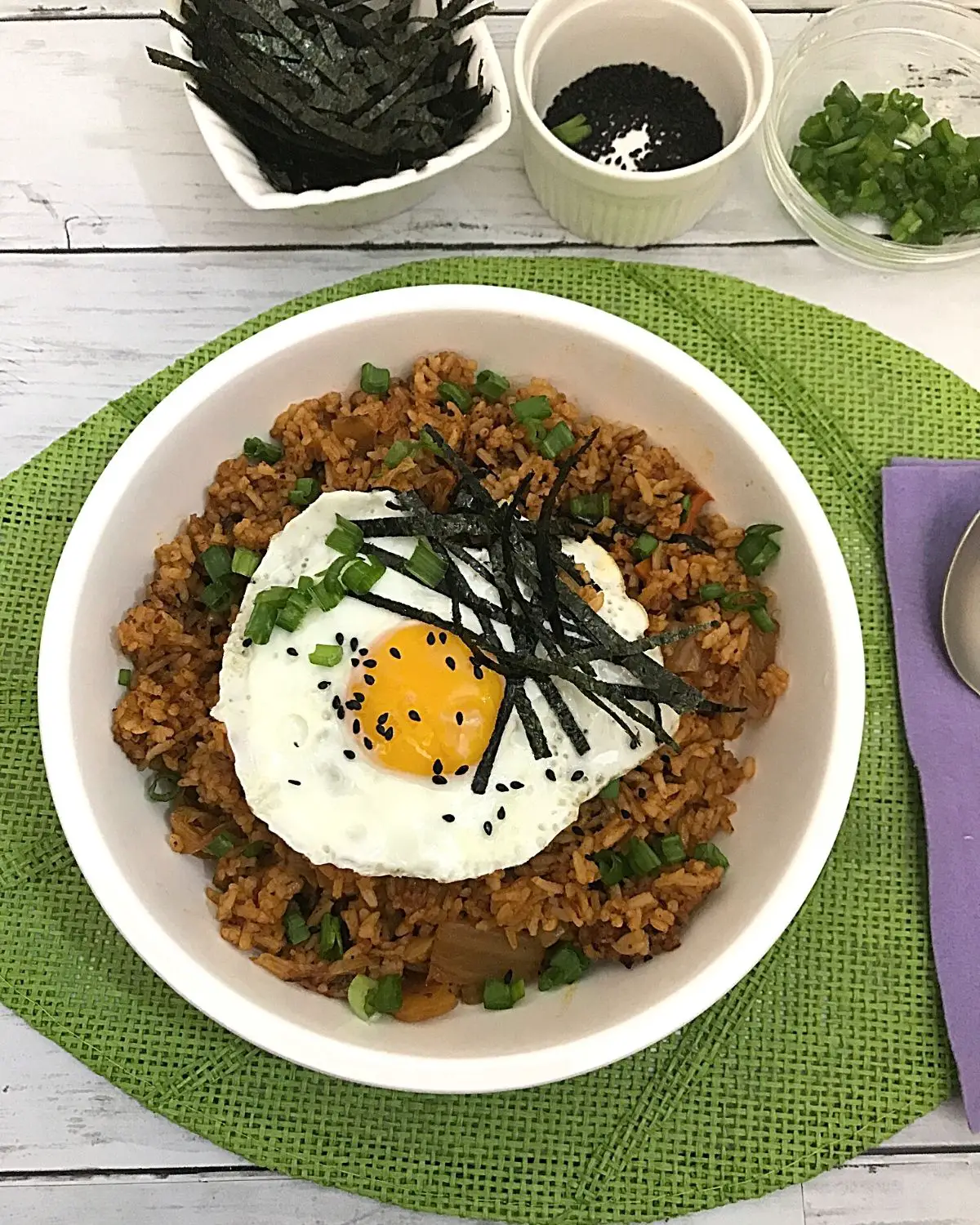 Kimchic fried rice served in a white large plate with some garnishing 