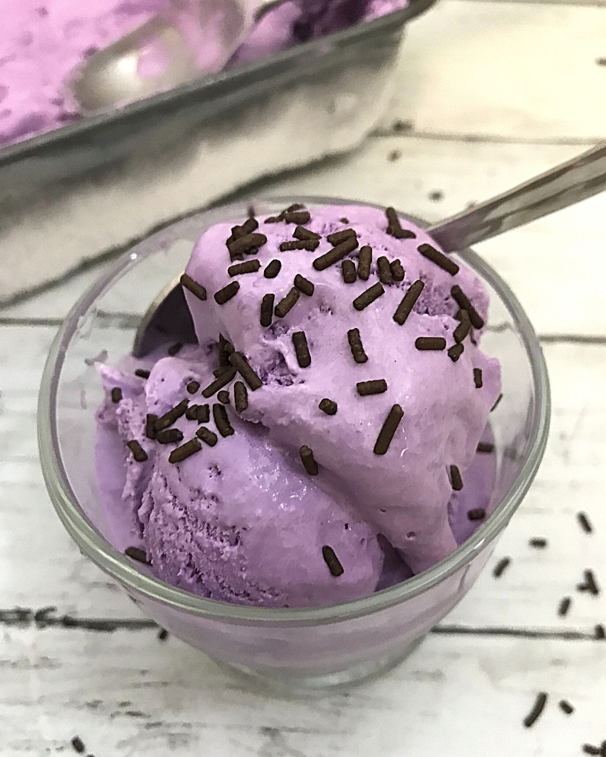 ube ice cream in a cup with chocolate sprinkles