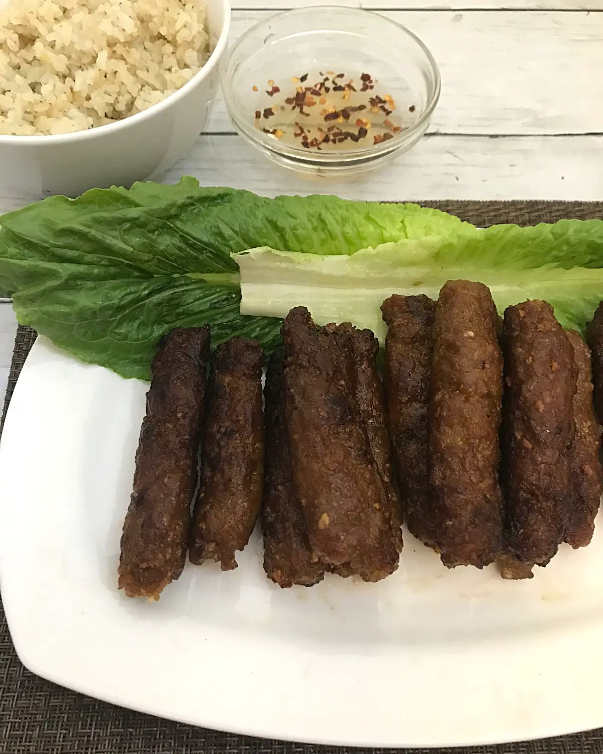 cooked filipino skinless longganisa sausage lined up in a serving plate